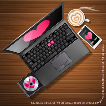 heart shape on laptop screen and mobile phone with latte art on wood background